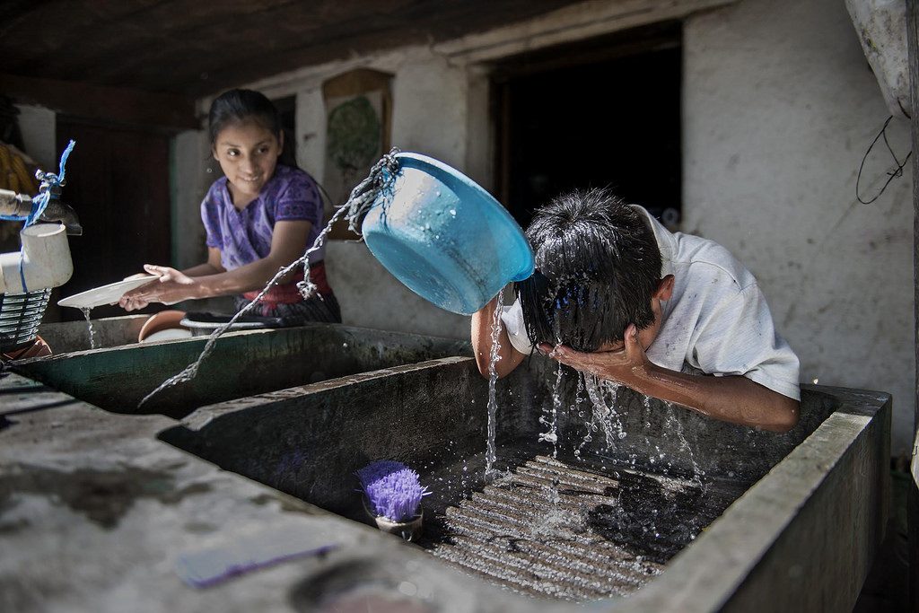 Niño se lava con agua corriente en la Comunidad de Xesampual, Sololá. Foto: Miguel Lizana / AECID